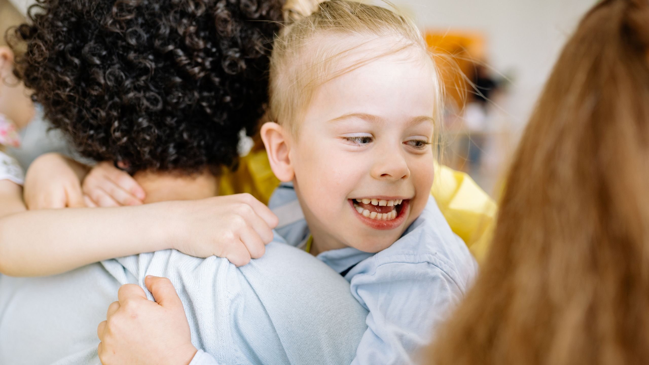 Happy children embrace indoors, sharing a moment of joy and friendship.